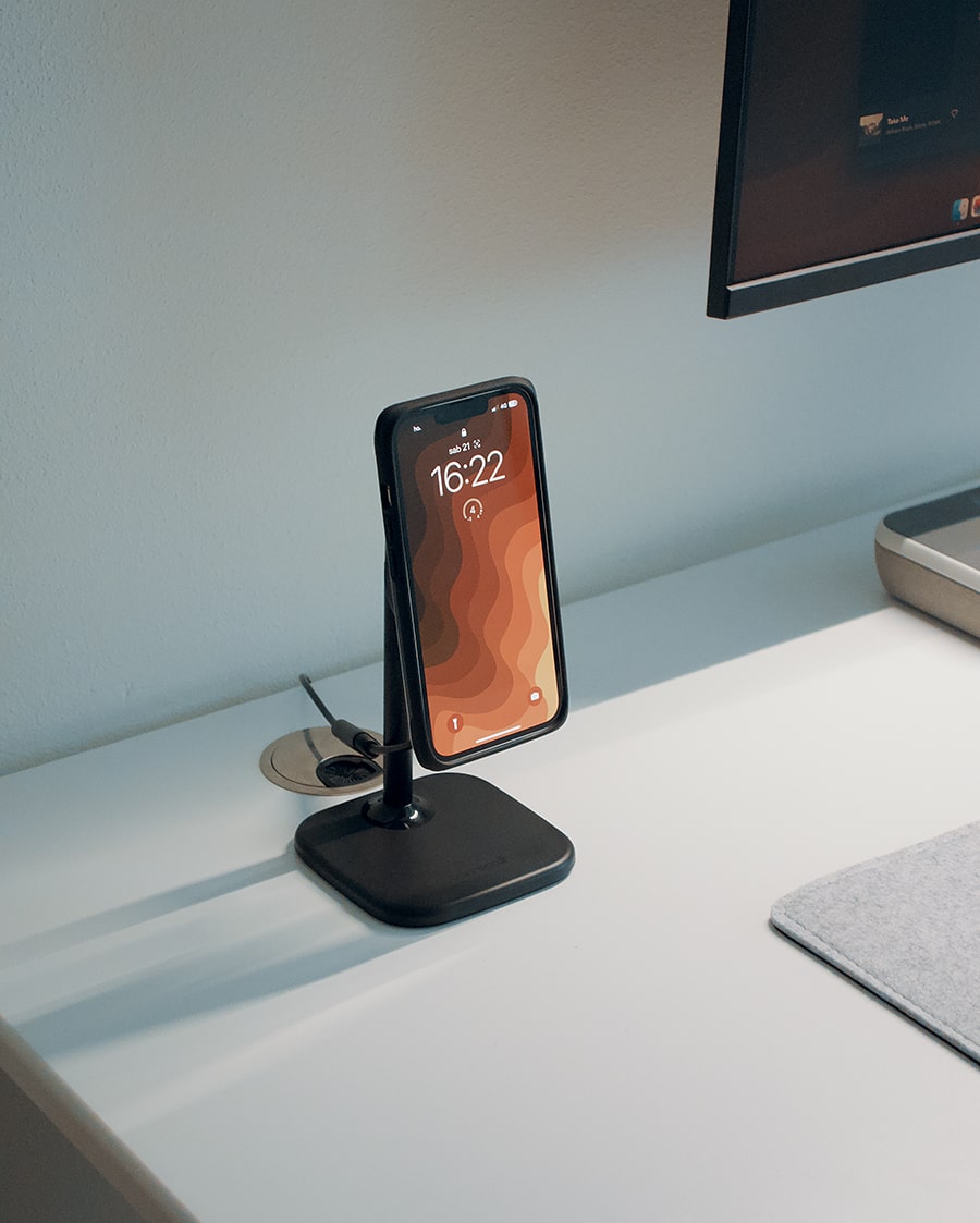 Wireless charging stand with smartphone support on a modern desk