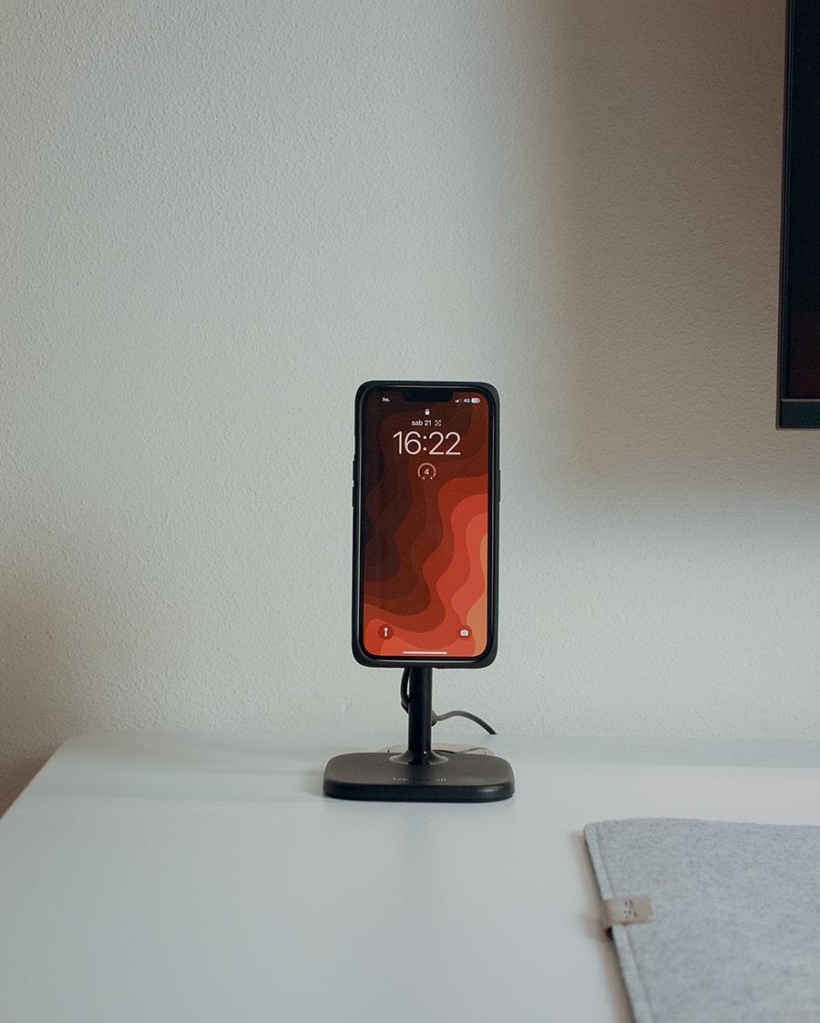 Smartphone charging on a magnetic wireless charging stand on a clean desk