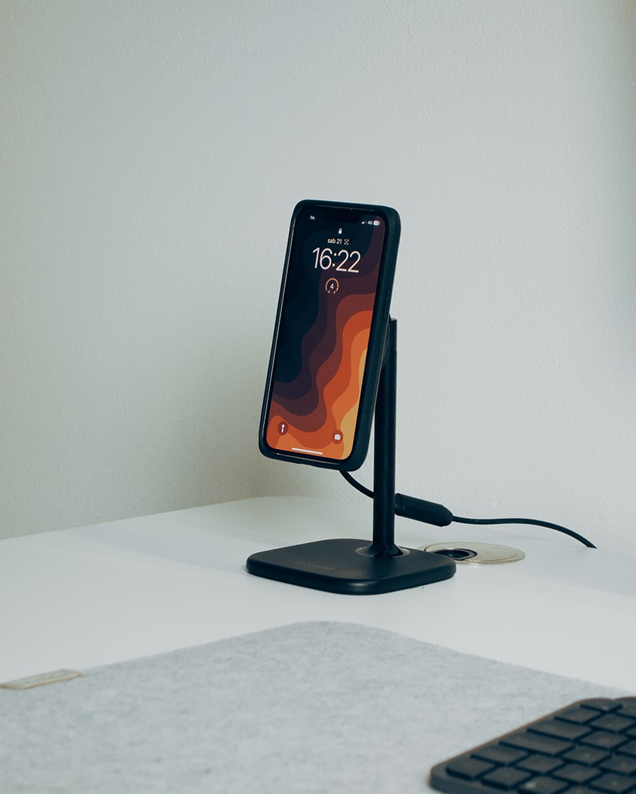 Wireless phone charging stand on a clean organized workspace with cable routed neatly