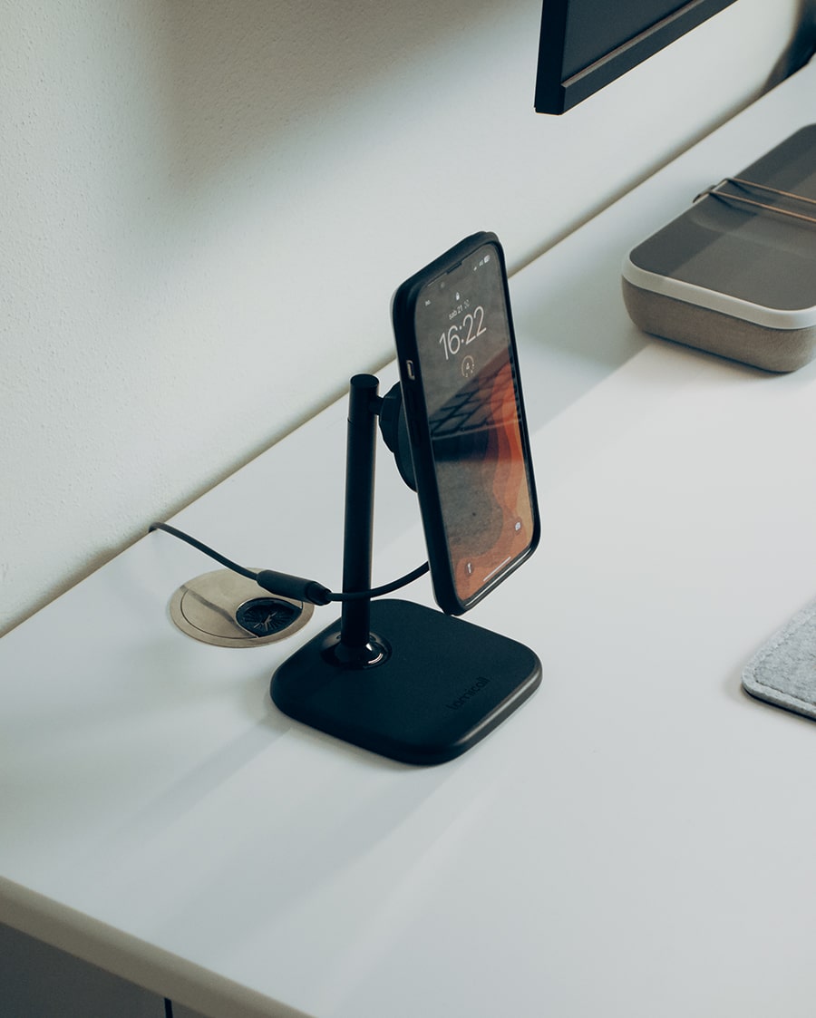 Phone aligned on a wireless charging stand for everyday desk charging